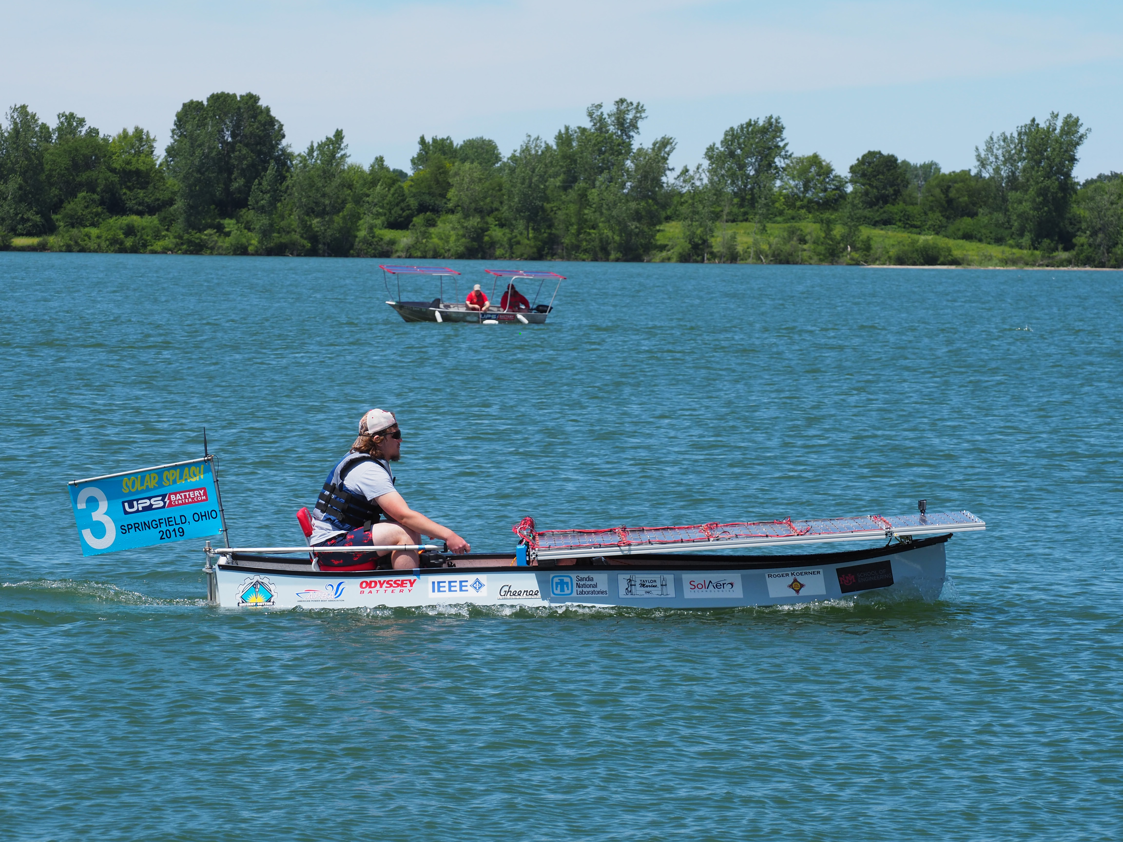 UNM solar splash team member driving boat